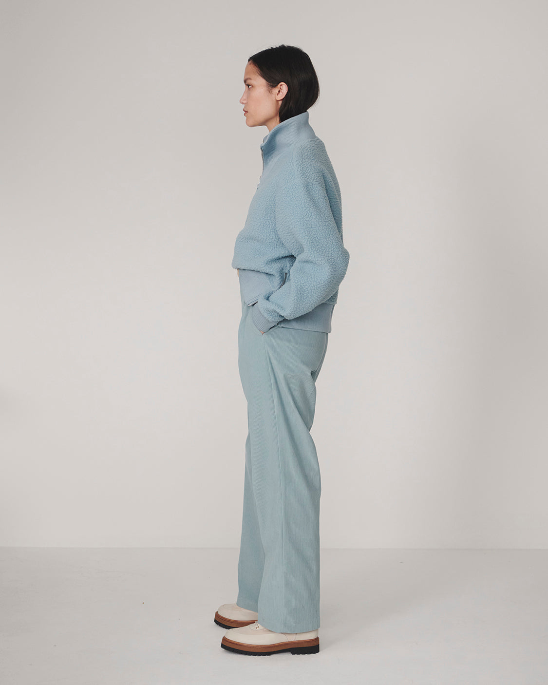 Varley Tourmaline Jaylin Half Zip Fleece in pale blue worn by a model in profile