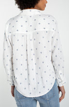 Back view of a woman wearing an Off White Long Sleeve Button Front Shirt With High Low Hem by liverpool with subtle diamond pattern.