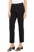 Woman wearing Black Rinse Liv Relaxed Skinny 28ins jeans from liverpool with black sandals and white top against white background