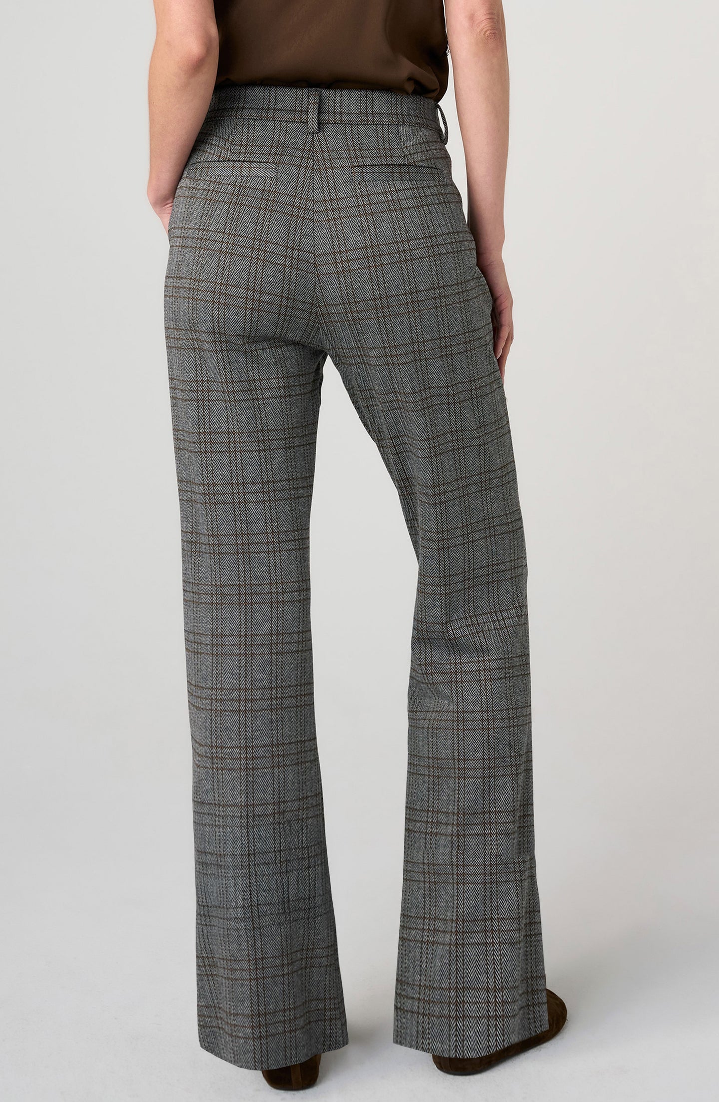 Back view of a person wearing Herringbone Kelsey Wide Leg Trouser by liverpool in grey plaid fabric, hands in pockets.