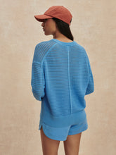 Woman wearing an Azure Blue Pembroke Knit Cardigan by Varley, shown from back with relaxed fit and textured knit pattern.