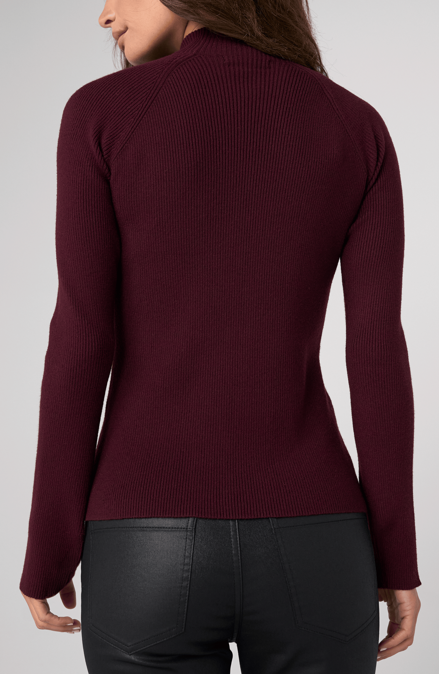 Back view of a woman wearing an Oxblood Turtleneck Sweater by liverpool with ribbed texture and fitted sleeves.