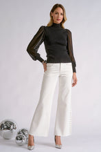 Elan Onyx black high-neck top with sheer sleeves, styled with white pants