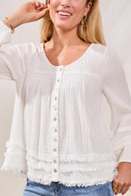 Woman wearing Tribal Ocean Pearl Crinkle Gauze Top in white with button details and fringe trim paired with denim jeans