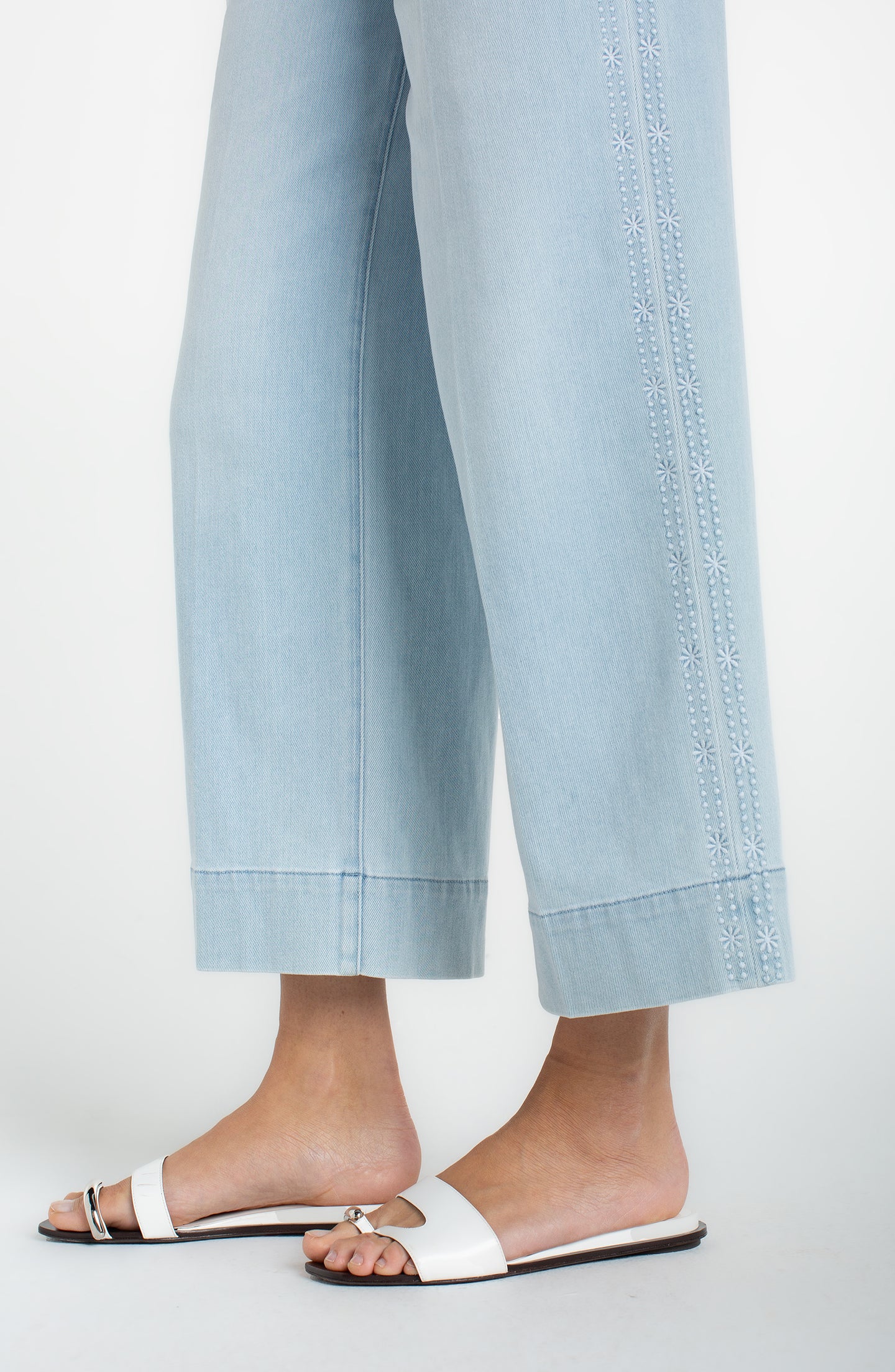 Light blue wide-leg cropped pants with floral embroidered side seams worn with white slide sandals Marine Flowers Stride Crop Wide Led w/ Embroidered Side Seam