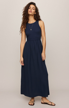 Woman wearing a navy sleeveless Eclipse Charlotte Midi Dress by z supply with a flattering fitted bodice and flowing skirt