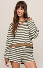 Woman wearing Monstera Low Key Stripe Sweatshirt by z supply in green and cream stripes with relaxed fit and brown accents