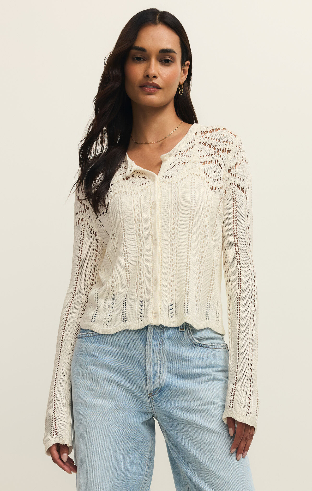 Woman wearing a white Cloud Alycia Crochet Sweater by z supply with delicate crochet details and button front closure