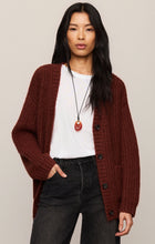 Woman wearing a Velvet Rouge Whitmore Cardigan by z supply in deep red over a white shirt with black pants.