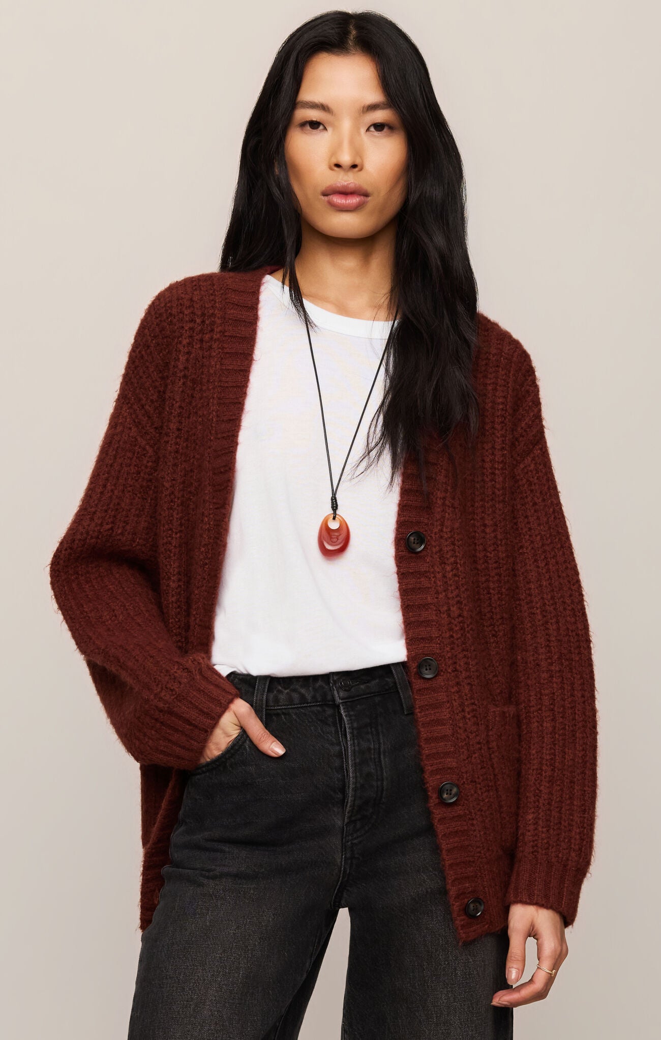 Woman wearing a Velvet Rouge Whitmore Cardigan by z supply in deep red over a white shirt with black pants.