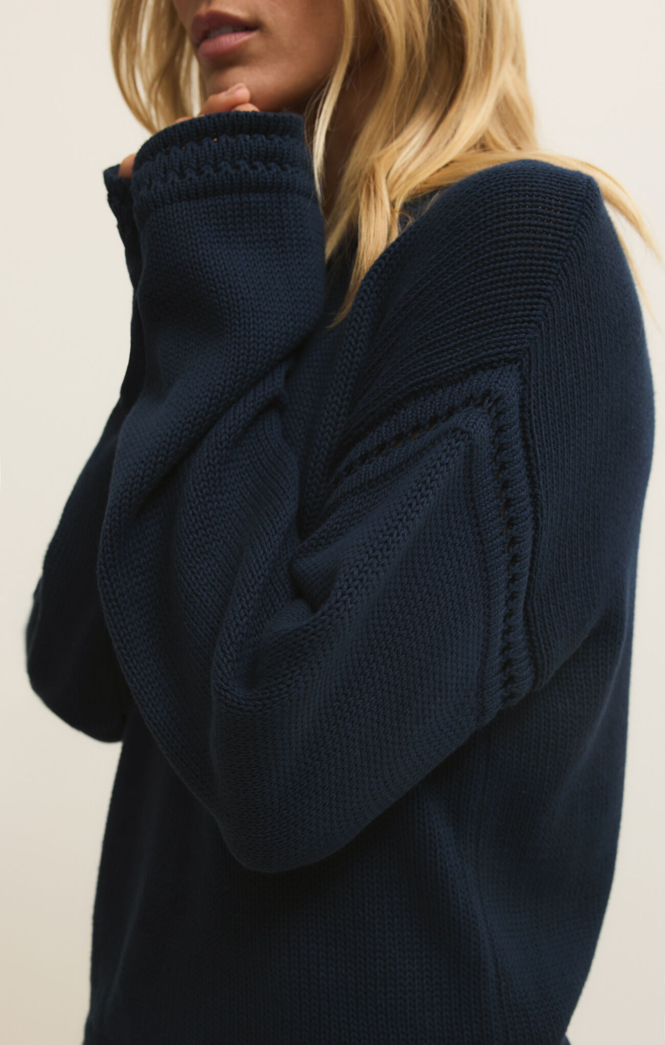 Close-up of a woman wearing the navy Eclipse Bellami Sweater by z supply featuring detailed knit pattern on sleeve and cuff