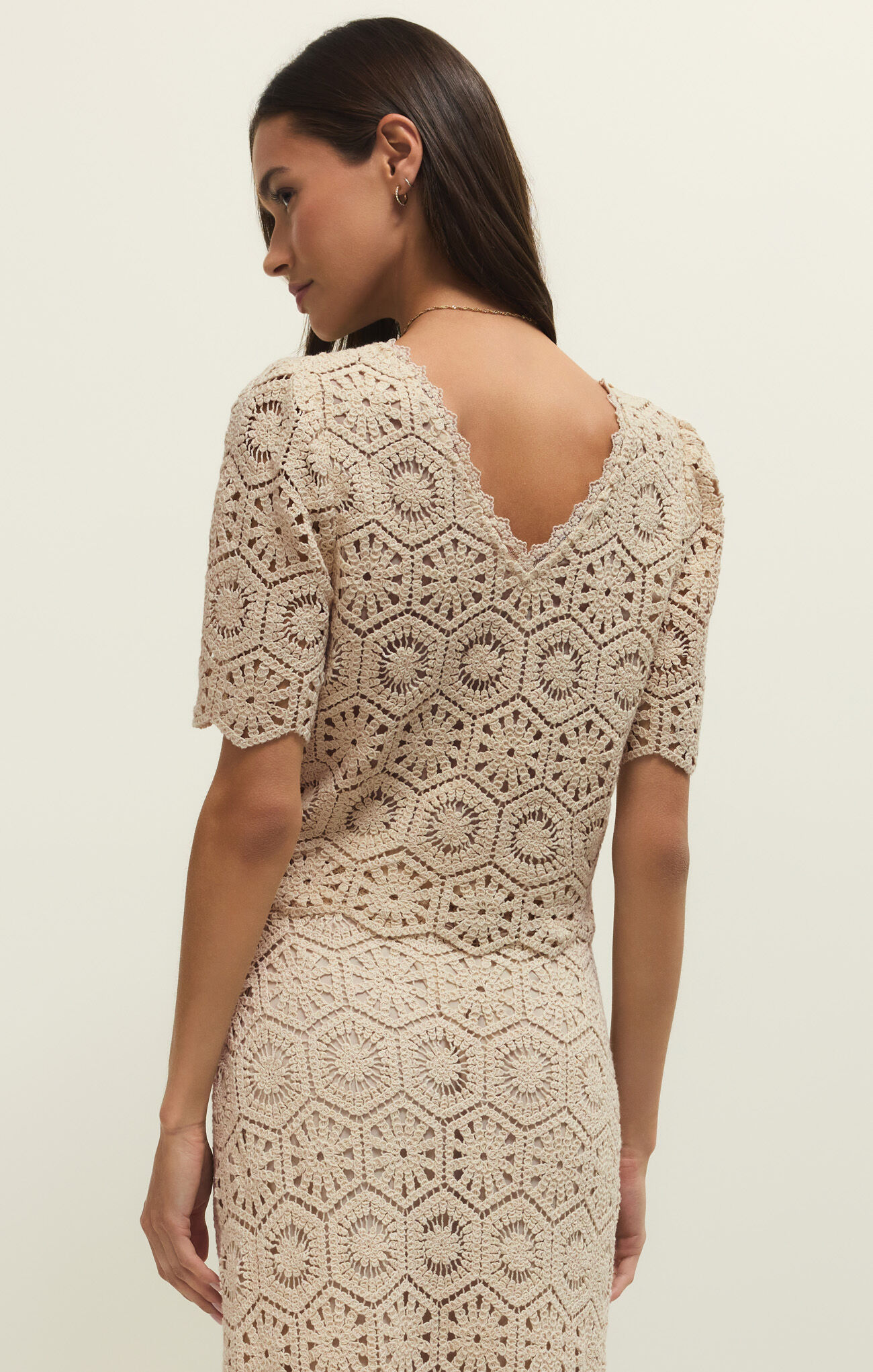 Woman wearing z supply Natural Raquel Lace Top in natural tones with intricate crochet pattern and scalloped V-back design