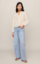Woman wearing Cloud Louella Button Up Top by z supply in cream with light blue wide-leg jeans and sandals
