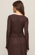 Woman wearing a sheer Dark Chocolate Amara Polka Dot Mesh Top by z supply, shown from the back with long sleeves