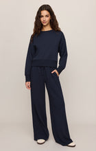 Woman wearing navy loungewear with wide-leg pants posing, featuring Eclipse Breakaway Track Pant by z supply.